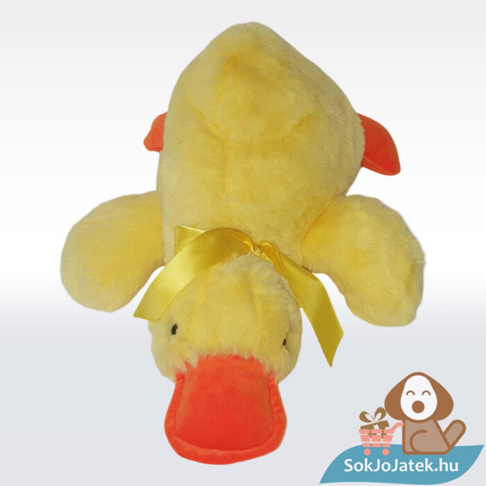 Átölelhető, hason fekvő, sárga plüss kacsa párna sárga masnival előről (36 cm)